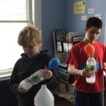 The balloons are filling with gas created by the mixing of a liquid - vinegar and a solid - baking soda. 
